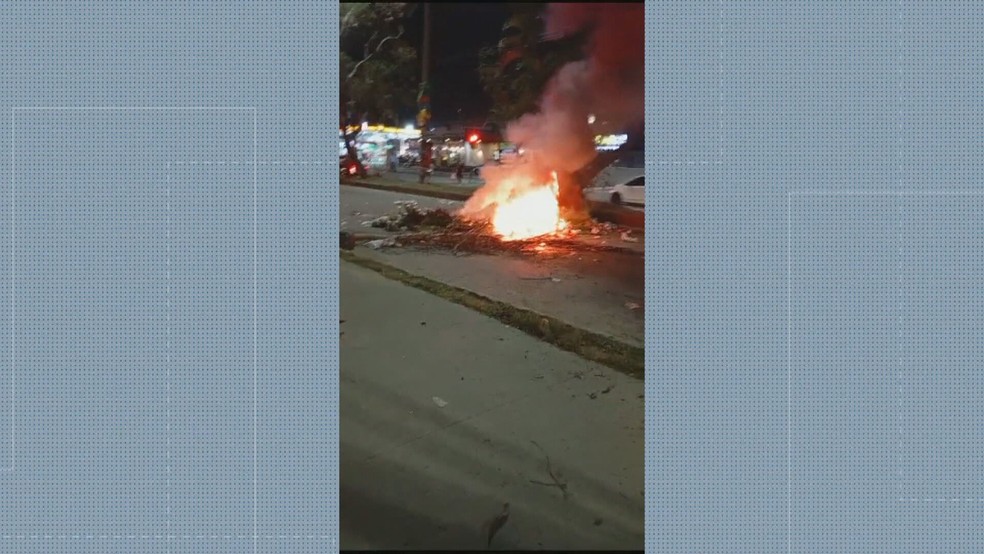 Após o ataque, moradores atearam fogo em objetos na Estrada dos Bandeirantes — Foto: Reprodução/TV Globo