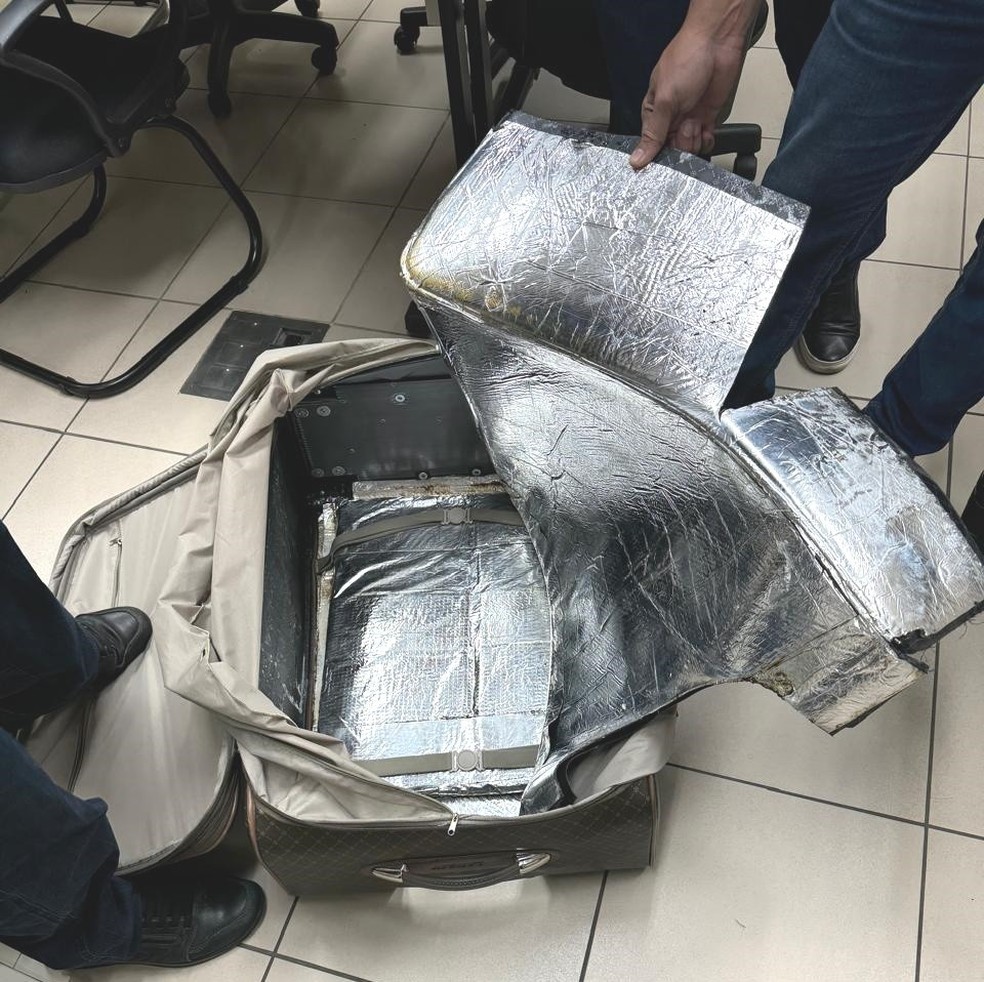 Suspeito escondia carga com quase 13 quilos de cocaína no forro da mala — Foto: Divulgação