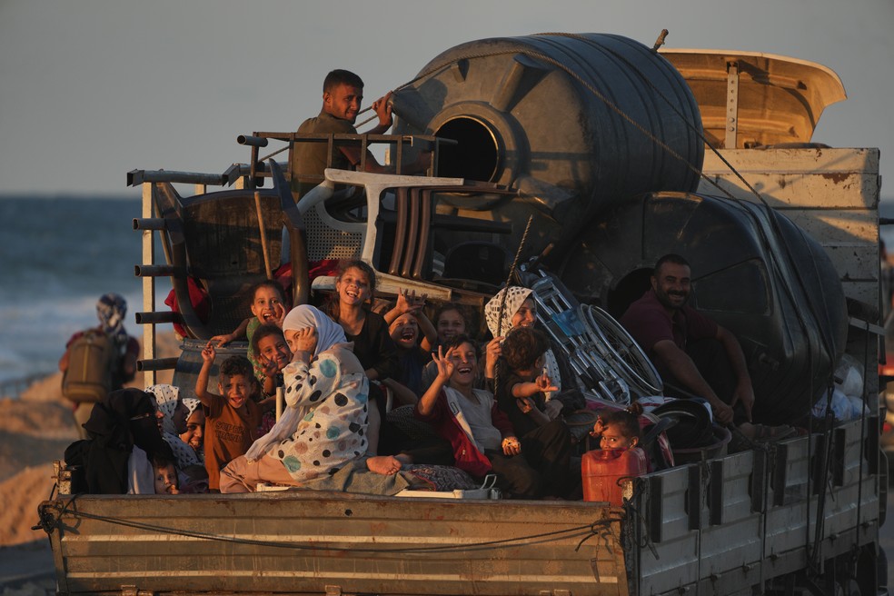 Famílias palestinas voltam para onde moravam após anúncio de cessar-fogo entre Hamas e Israel — Foto: Abdel Kareem Hana/AP