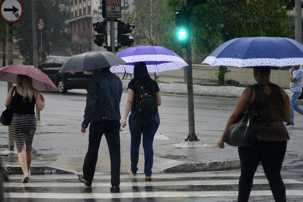 Pedestres com guarda-chuva em São Paulo — Foto: CRIS FAGA/DRAGONFLY PRESS/ESTADÃO CONTEÚDO