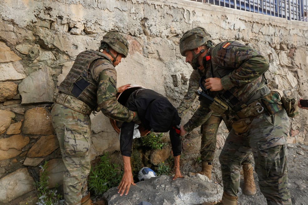 Soldados espanhóis encontram um migrante escondido em um túnel na praia de Tarajal — Foto: REUTERS/Jon Nazca