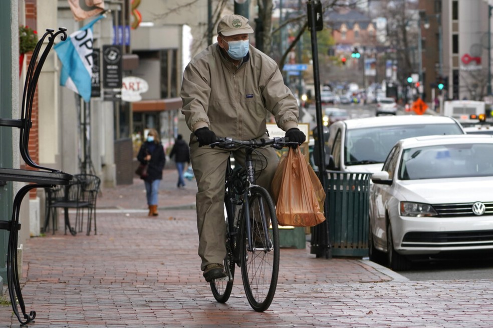 Usando mscara, homem pedala nas ruas de Portland durante a pandemia  Foto: Robert F. Bukaty/AP Photo