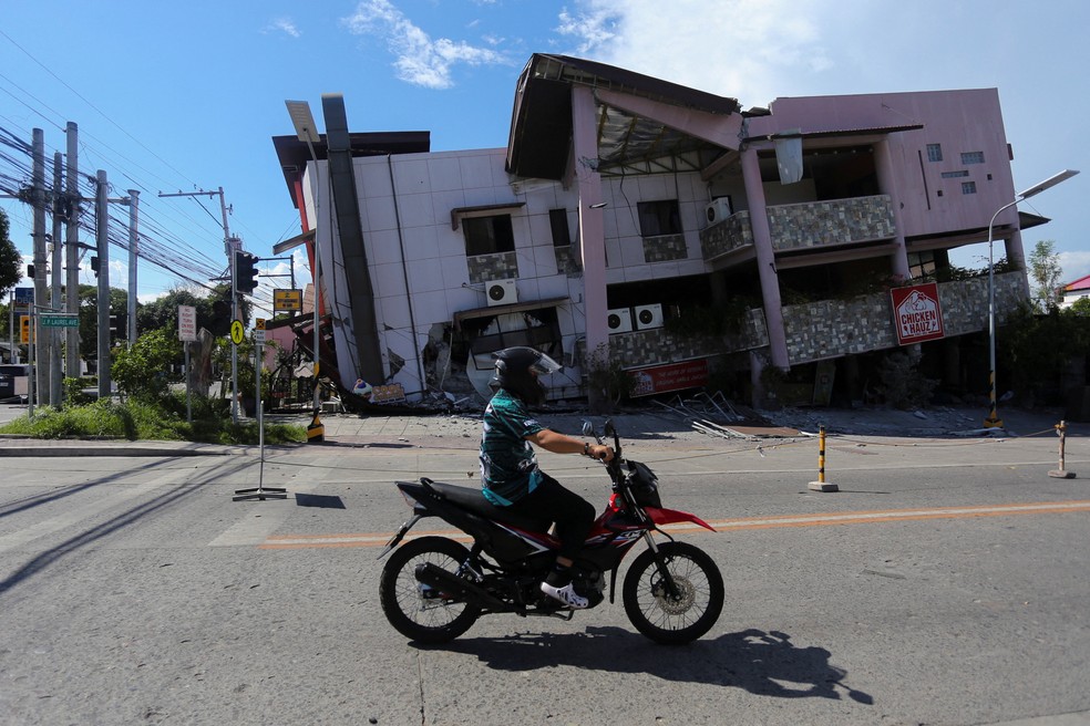 Um motociclista passa por um pr&eacute;dio danificado ap&oacute;s o terremoto &mdash; Foto: Reuters
