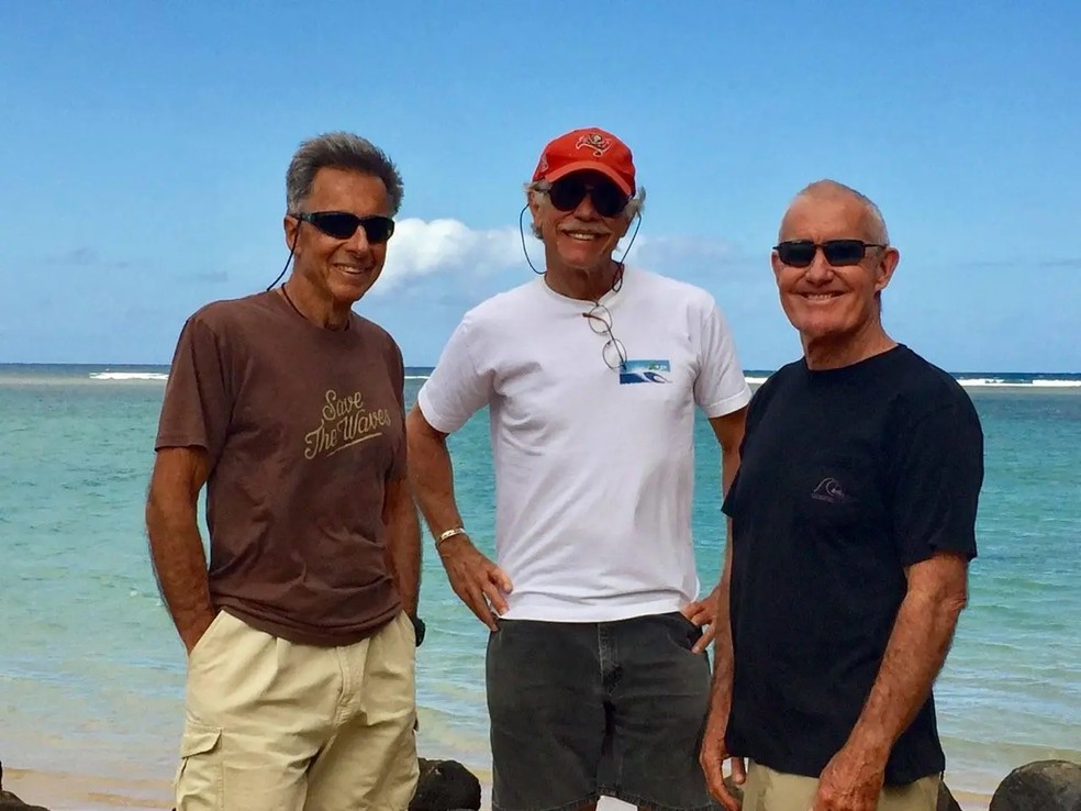 Pomar ao lado dos amigos Tom Woods e Jeff Hakman, criadores do Surf Till 100 — Foto: Divulgação