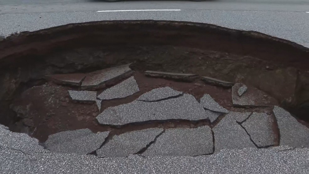 Cratera do tamanho de um carro chama atenção no bairro Belvedere, em BH — Foto: Reprodução/TV Globo