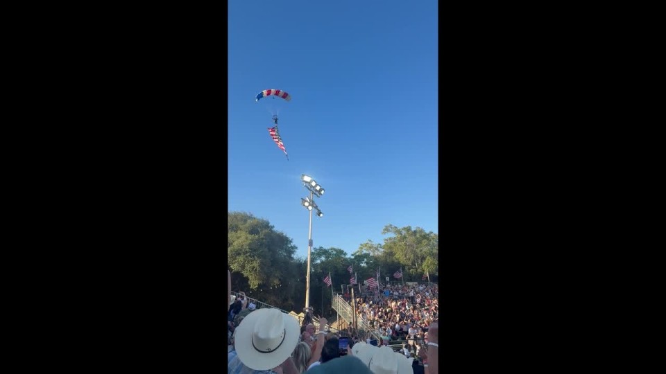 VÍDEO: Paraquedista amarrado à bandeira gigante dos EUA se enrosca em árvore e cai sobre tenda