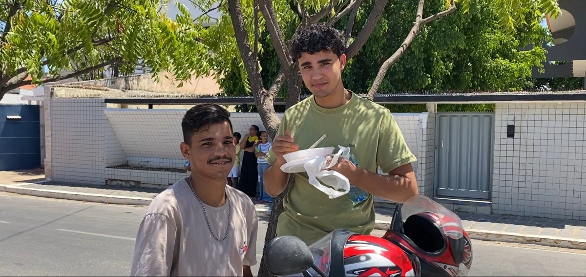 Estudante almoça em pé em frente ao local de prova antes de fazer o Enem 2025 no Sertão da PB: 'não queria atrapalhar'