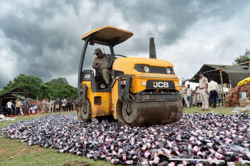 Polícia na Índia esmaga xaropes para tosse à base de codeína apreendidos com um rolo compressor para marcar o 'Dia da Destruição de Drogas' — Foto: NurPhoto via Getty Images