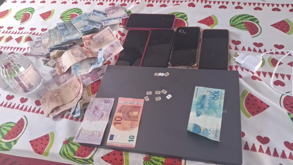Polícia apreendeu seis celulares, um notebook, mais de nove chips de telefonia e uma quantia em dinheiro — Foto: Reprodução