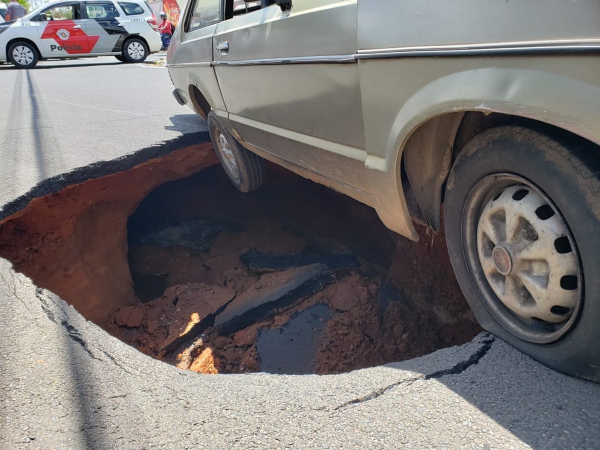 Asfalto cede e carro quase é 'engolido' por cratera no centro de ...