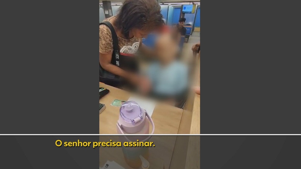 Mulher leva corpo em cadeira de rodas para sacar empréstimo no Rio — Foto: Reprodução/TV Globo