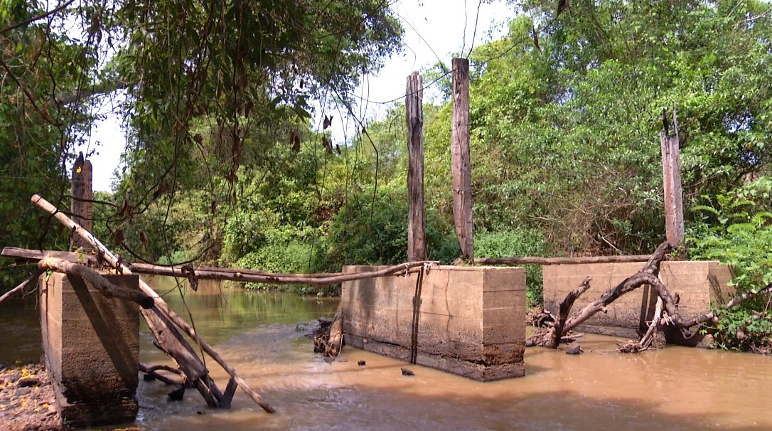 Moradores esperam reconstrução de ponte há quatro anos e se arriscam em travessia: 'Pinguela com a água na cintura'