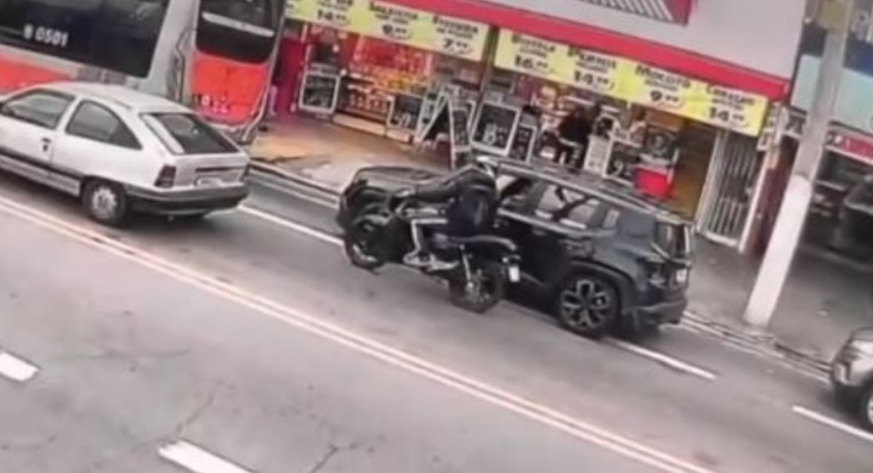 Câmera gravou momento em que criminoso em moto atira em Dato de Oliveira, que estava no carro preto — Foto: Reprodução/Redes sociais