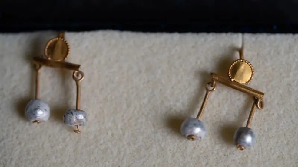Um par de brincos de ouro e pérolas foi encontrado perto do esqueleto feminino. — Foto: TONY JOLLIFFE/BBC
