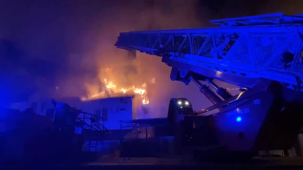 Bombeiros apagam um carro em chamas no pátio de um prédio de apartamentos após um ataque de mísseis das Forças Armadas da Ucrânia. — Foto: Canal do Telegram do governador da região de Belgorod, Vyacheslav Gladkov, via AP