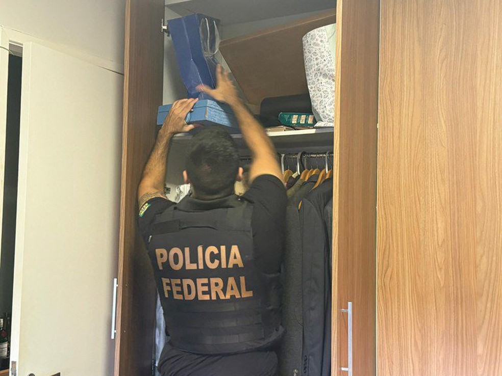 Agente da Polícia Federal realiza buscas no apartamento de um dos investigados. — Foto: Divulgação/PF