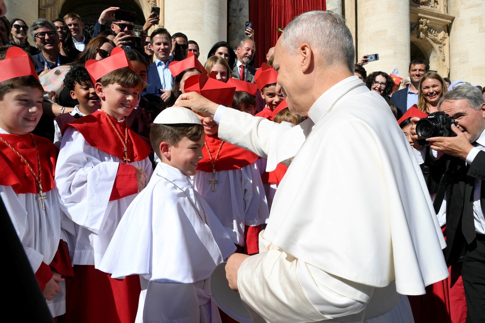 Papa Leão XIV brinca com estudante de escola de Chicago que fez 'miniconclave' durante visita dos alunos ao Vaticano, em 8 de outubro de 2025. — Foto: Vatican Media/Simone Risoluti via Reuters