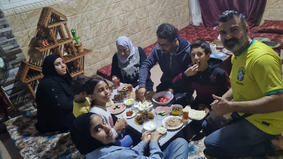 Brasileiros fazem refeição em casa na cidade palestina de Rafah, onde aguardam autorização para atravessar fronteira com Egito — Foto: Divulgação/Embaixada do Brasil na Palestina