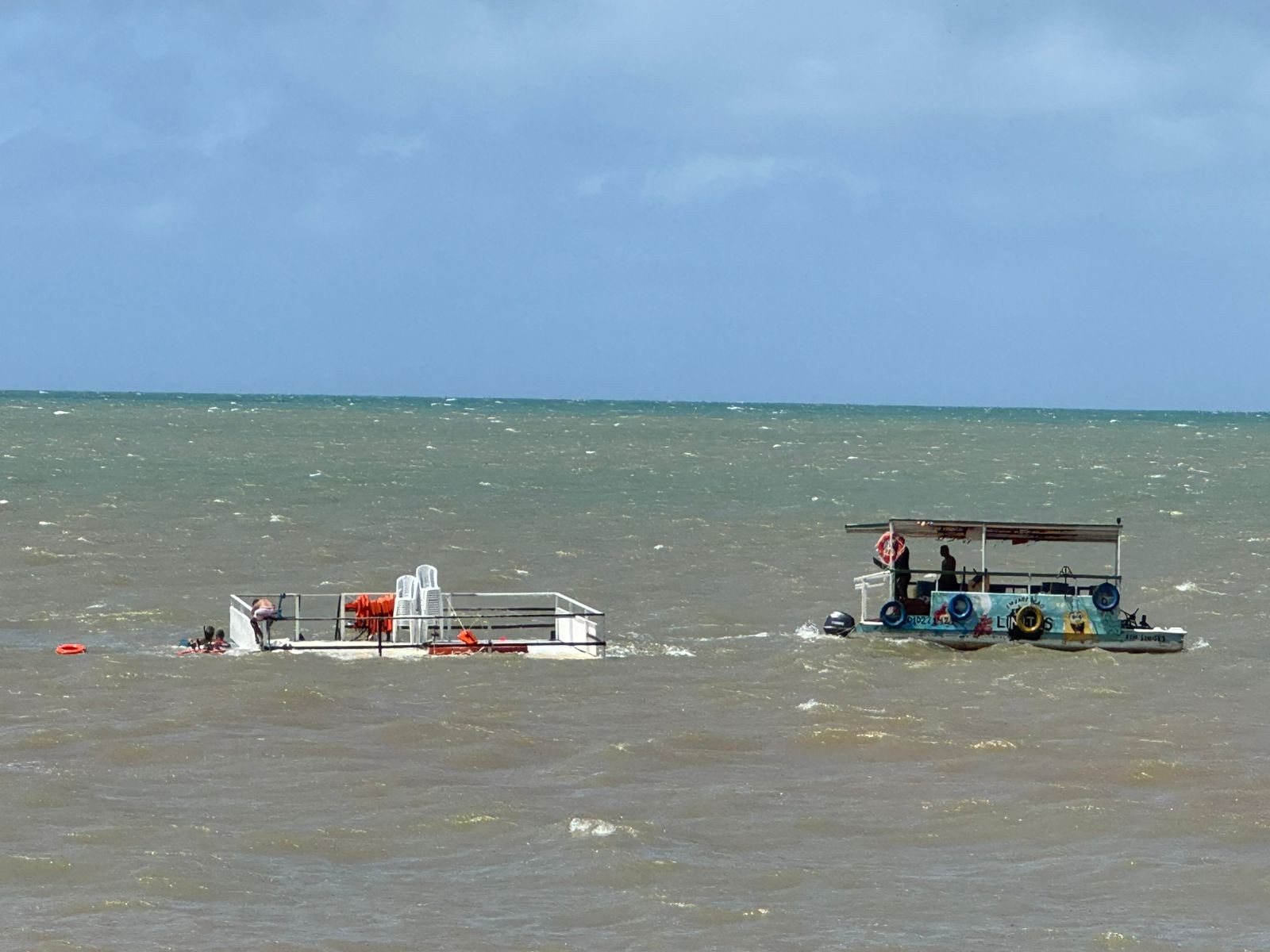 Catamarã afunda na praia do Seixas, em João Pessoa, e precisa ser retirado do mar por barco menor