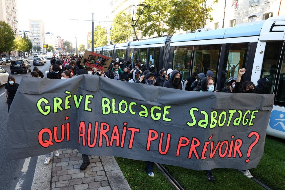Estudantes seguram uma faixa com os dizeres "greve, bloqueio, sabotagem, quem poderia ter previsto?" enquanto bloqueiam a linha do bonde em Paris, como parte de um dia de greves e protestos nacionais contra o governo e os cortes previstos no próximo orçamento, com o apoio do movimento "Bloquons Tout" (Vamos Bloquear Tudo). — Foto: REUTERS/Tom Nicholson