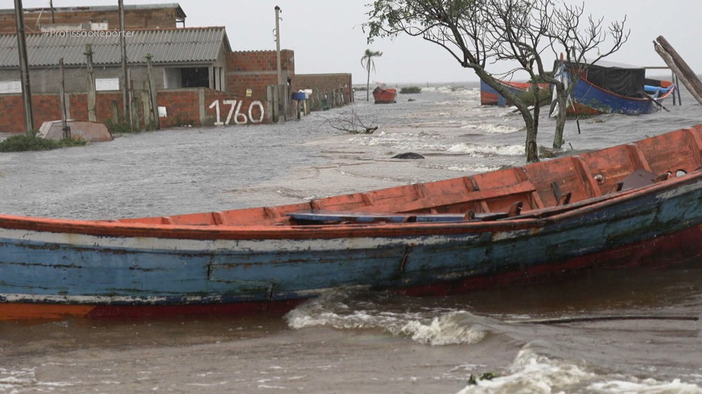 Morador no RS tem vivido com uma canoa na porta de casa, monitorando o quanto a água sobe dentro da residência — Foto: Reprodução/TV Globo