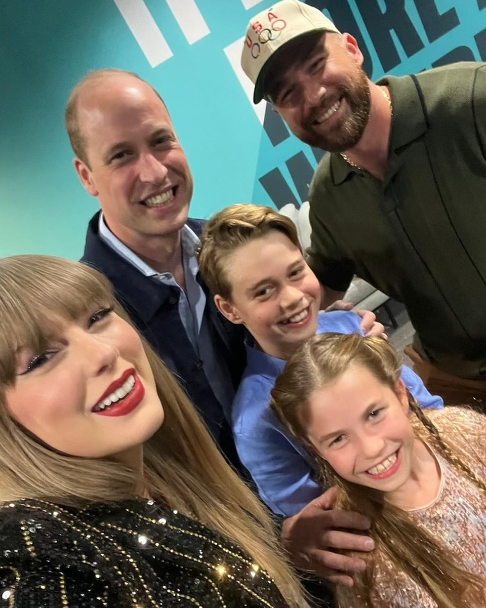Selfie postada por Taylor Swift no Instagram mostra a cantora ao lado de seu namorado, Travis Kelce, do príncipe William e dos dois filhos mais velhos dele, George e Charlotte — Foto: Reprodução/Instagram