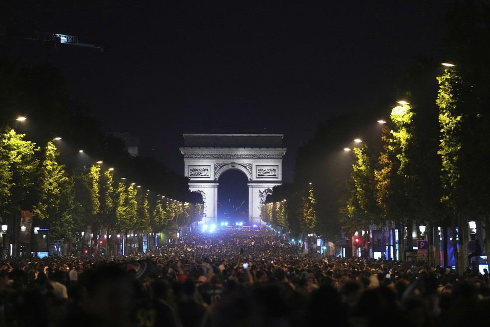 Fs comemoram a vitria do PSG na Champions League na avenida Champs Elyse, com o Arco do Triunfo ao fundo  Foto: Aurelien Morissard/AP Photo