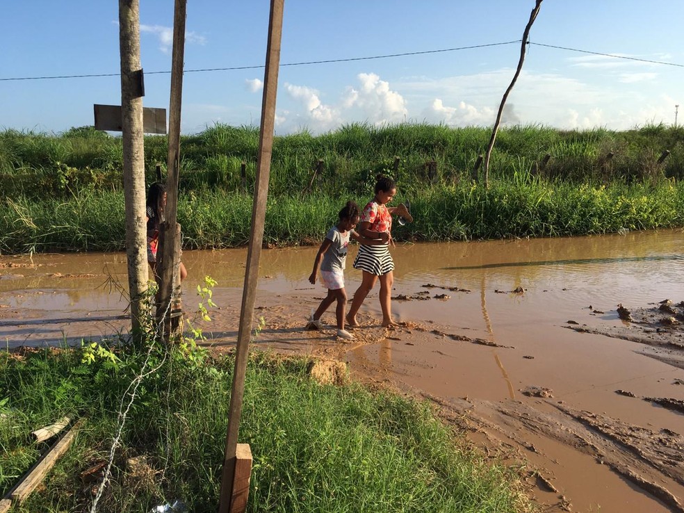 Moradores usam sacola nos pés para atravessar rua com lamaçal em MT, Mato  Grosso
