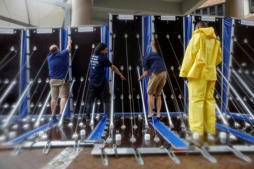 Homens colocam barreiras ao redor do Hospital Geral de Tampa para prevenir enchentes por conta do furacão Milton, em Tampa, na Flórida, em 9 de outubro de 2024. — Foto: Octavio Jones/ AP