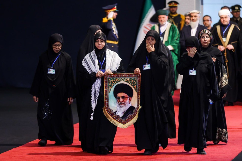 Mulheres enlutadas carregam homenagem a Ali Khamenei — Foto: Agência Tasnim