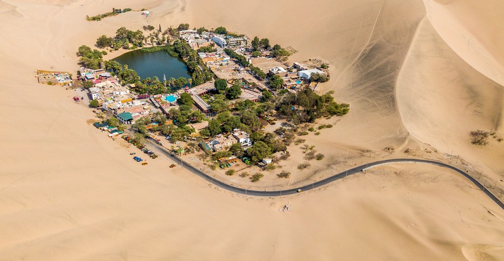 Oásis de Huacachina é cercado por árvores e casas — Foto: Willian Justen de Vasconcellos/Unsplash