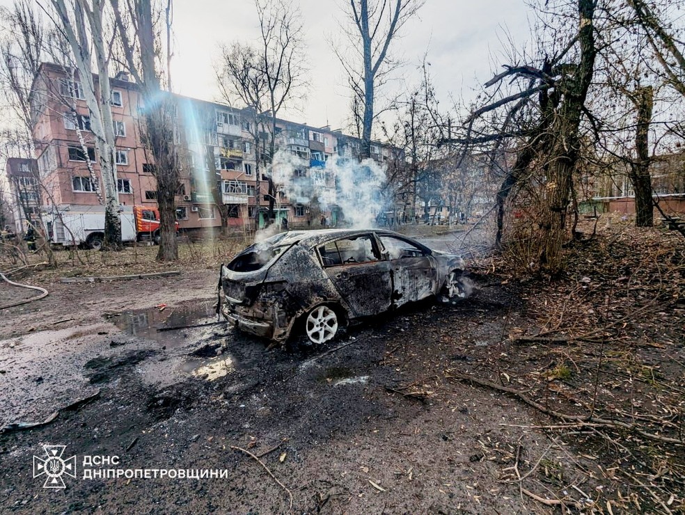 Um carro incendiado em frente a um edifício de apartamentos danificado por um ataque de míssil russo, em meio ao ataque da Rússia à Ucrânia, em Kryvyi Rih — Foto: Serviço Estatal de Emergência da Ucrânia/Divulgação via Reuters