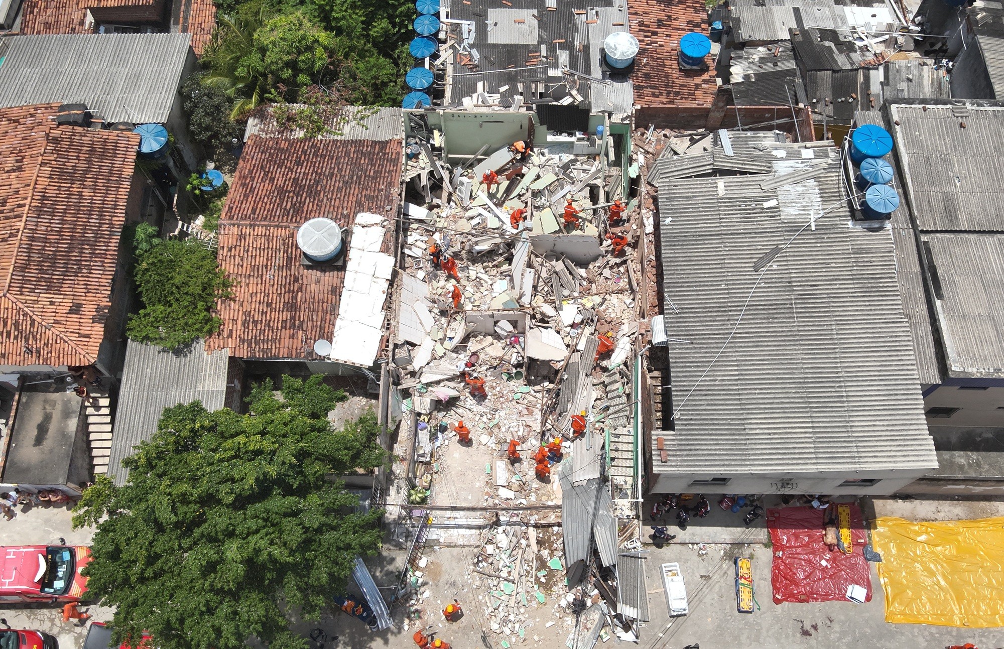 Vizinhos relatam cheiro de gás após explosão que matou dois homens e destruiu oito casas; idosa está sob escombros