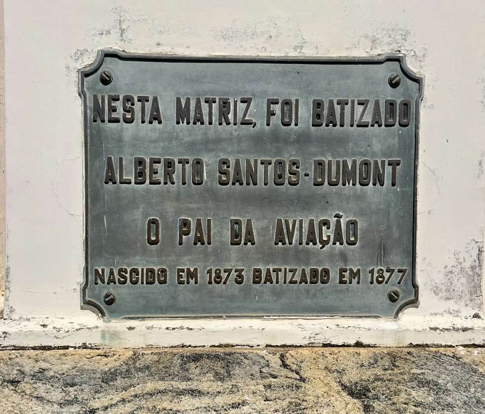 Placa com a informação de batismo de Santos Dumont em igreja de Rio das Flores — Foto: Divulgação