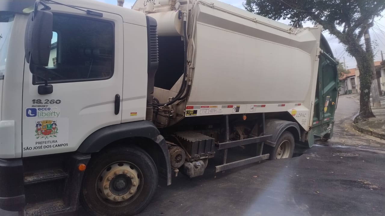 Caminhão da coleta de lixo afunda em buraco na rua em São José dos Campos, SP