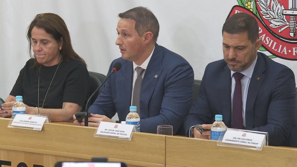 O secretário da Segurança Pública, Guilherme Derrite (PL), ao lado do atual delegado geral da Polícia Civil de SP, Artur Dian, e Evalda Aleixo, diretora do DHPP. — Foto: Reprodução/TV Globo