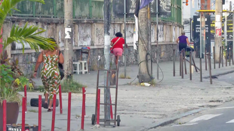 Pessoas correm na Avenida Itaoca, no Alemão, para fugir de tiros — Foto: Charles Mathura/TV Globo