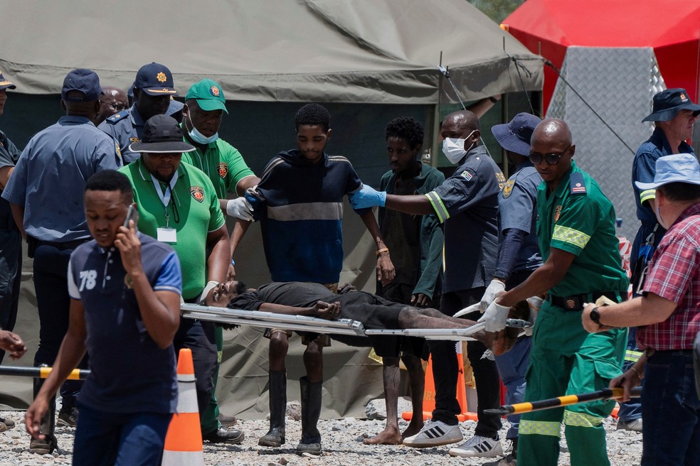 Homem recebe cuidados médicos após ser resgatado de mina ilegal na África do Sul — Foto: REUTERS/Ihsaan Haffejee