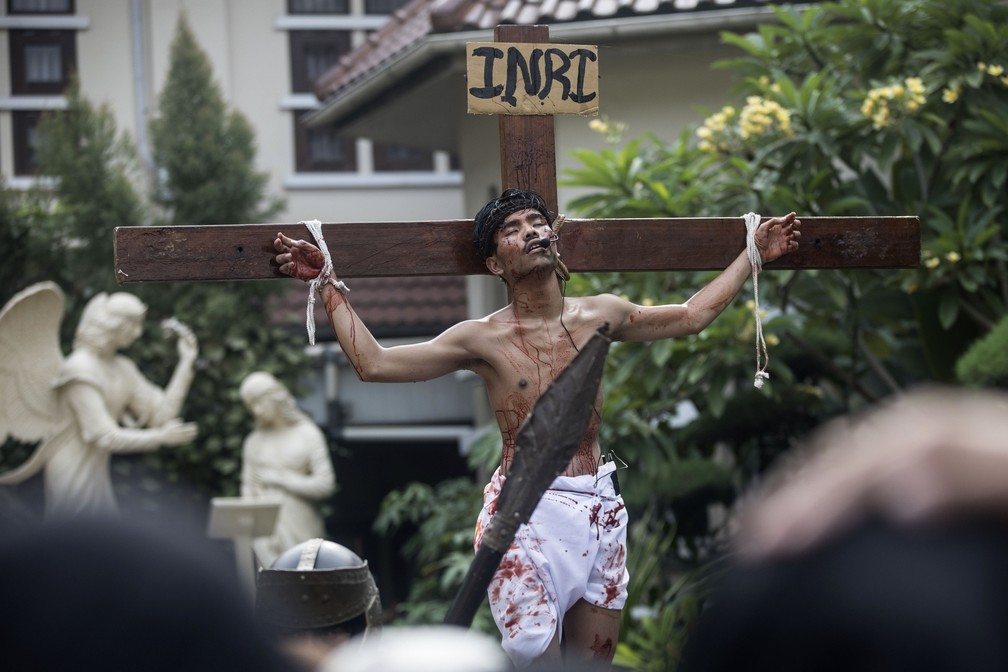 Homem desempenha o papel de Jesus Cristo em crucificação simulada durante procissão da Sexta-Feira Santa na catedral da cidade de Medan, Sumatra do Norte, Indonésia, nesta sexta-feira (29) — Foto: Binsar Bakkara/AP