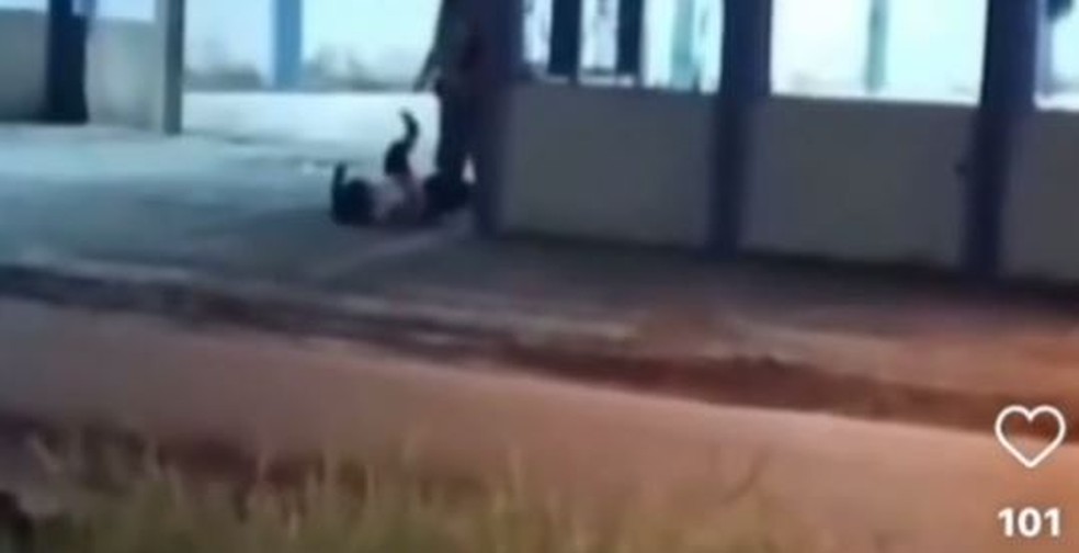 Vídeo mostra mulher caída no chão e segurança a agredindo com chutes e golpes de cacetete — Foto: Reprodução