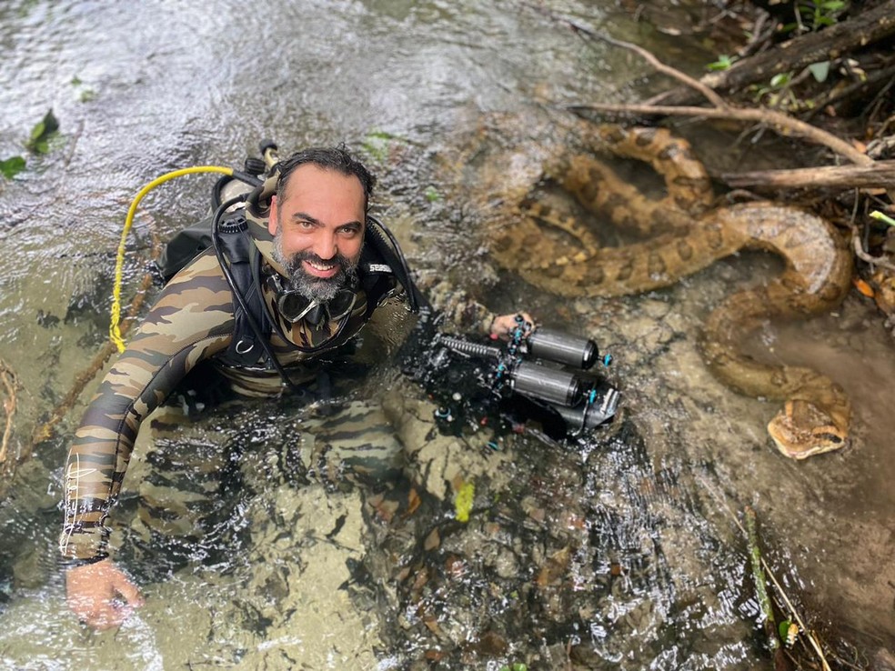 Documentarista junto da cobra gigante. — Foto: Arquivo Pessoal