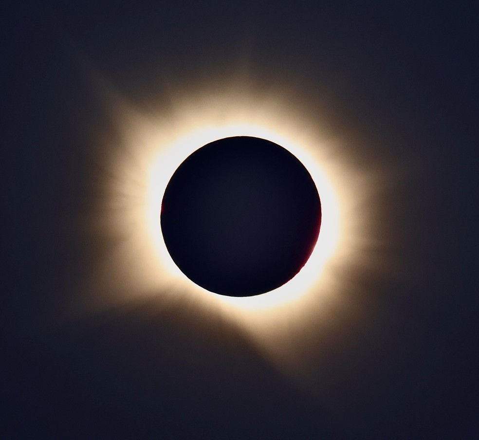 A coroa solar se estende para além do disco encoberto pela Lua e revela regiões mais densas, filamentos e outras estruturas moldadas pelo campo magnético do Sol. — Foto: Kiko Fairbairn / @kikofairbairn
