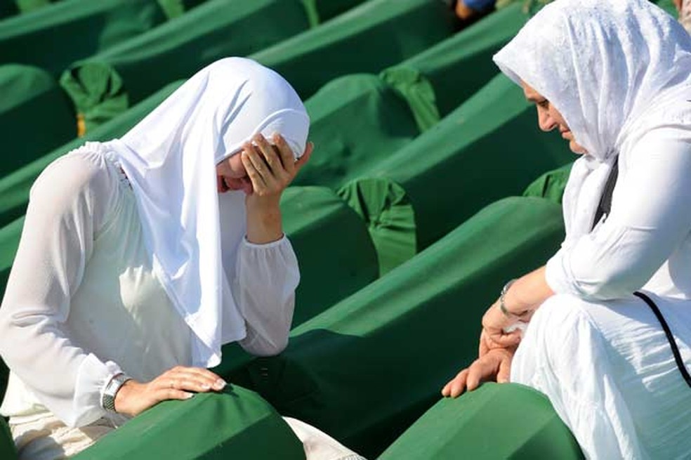 Muçulmanas choram durante funeral em Srebrenica. — Foto: AFP