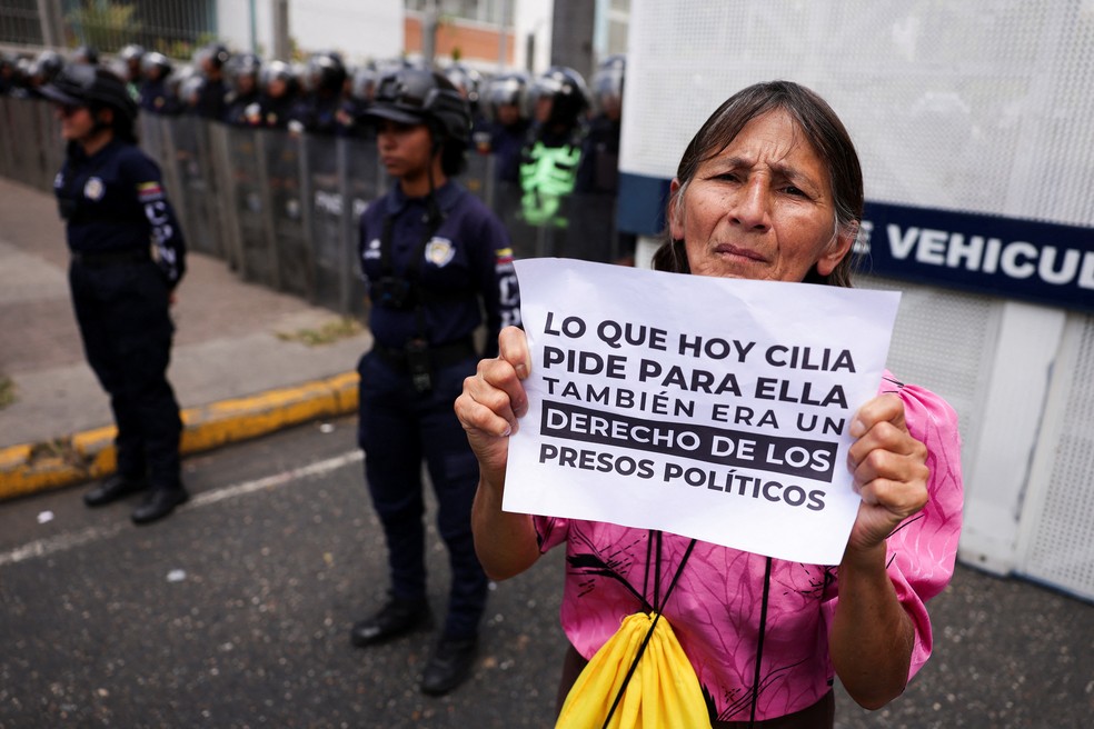 Uma mulher segura uma placa com os dizeres “O que Cilia está pedindo hoje também era um direito dos presos políticos”, enquanto familiares de presos políticos e ativistas participam de um protesto exigindo a libertação de seus entes queridos em Caracas, Venezuela — Foto: REUTERS/Gaby Oraa