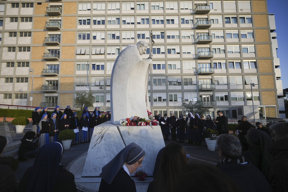 Religiosos rezam em frente ao hospital onde o papa está internado, em Roma — Foto: Alessandra Tarantino/AP
