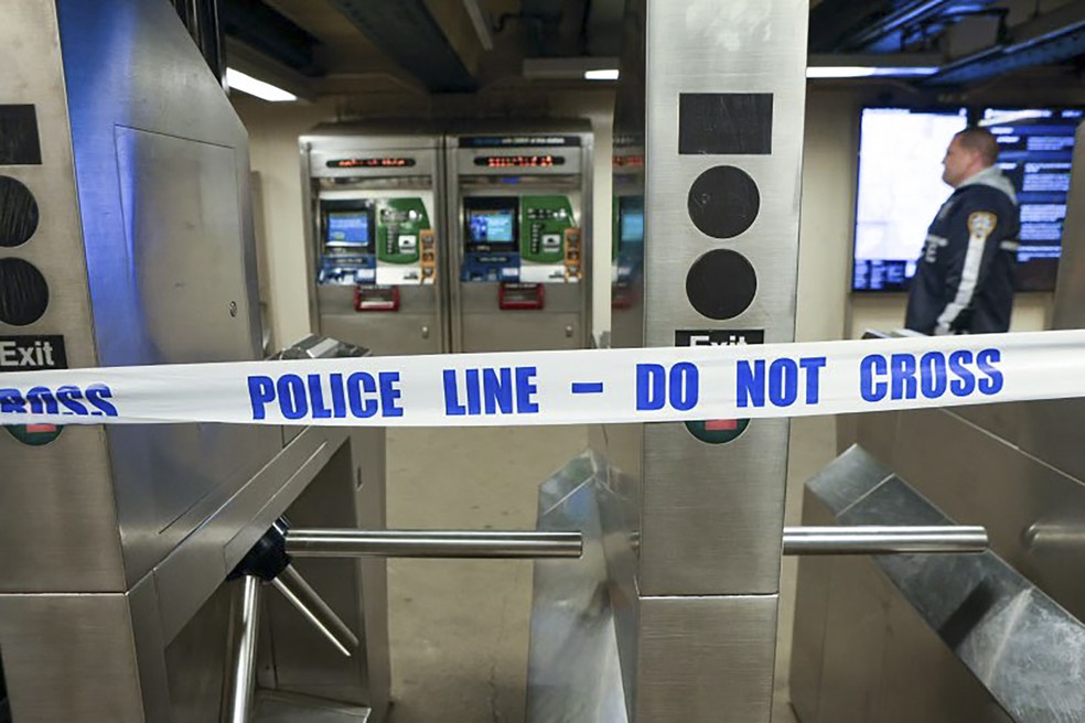 A polícia de Nova York caminha pela estação de metrô Mount Eden enquanto investiga um tiroteio — Foto: NYPD/AP