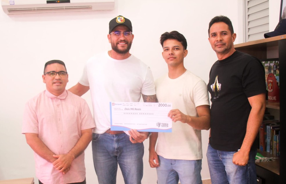 Prefeito Siqueira Fonseca entregando premiação de R$ 2 mil ao jovem José Marcos dos Santos, vencedor do concurso — Foto: Ascom/ Prefeitura de Terra Santa