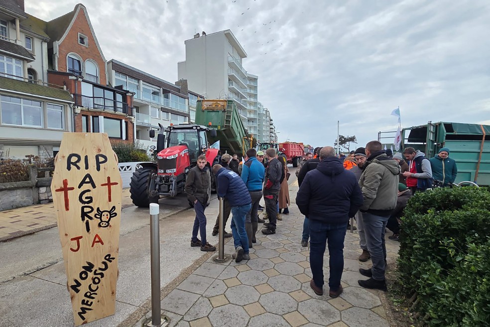 Agricultores com placa de oposição ao Mercosul em frente à casa de praia de Emmanuel Macron em Le Toquet, na França, em 19 de dezembro de 2025 — Foto: JEROME NOEL / AFP