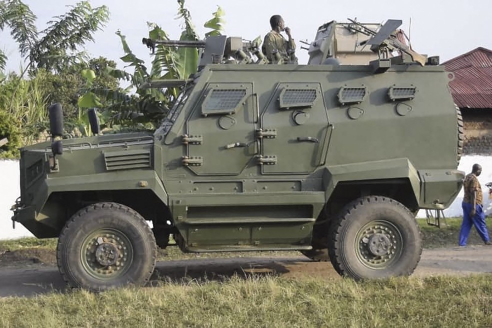 Veículo blindado da Força de Defesa do Povo de Uganda é visto perto de escola alvo de ataque com mortos em Mpondwe — Foto: AFP