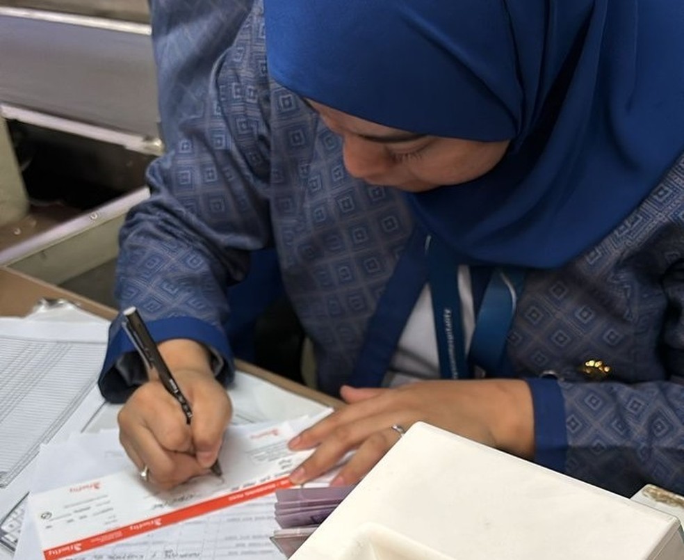 Funcion&aacute;ria da FireFly, empresa a&eacute;rea da Mal&aacute;sia, escreve cart&atilde;o de embarque &agrave; m&atilde;o &mdash; Foto: Reprodu&ccedil;&atilde;o/Redes sociais